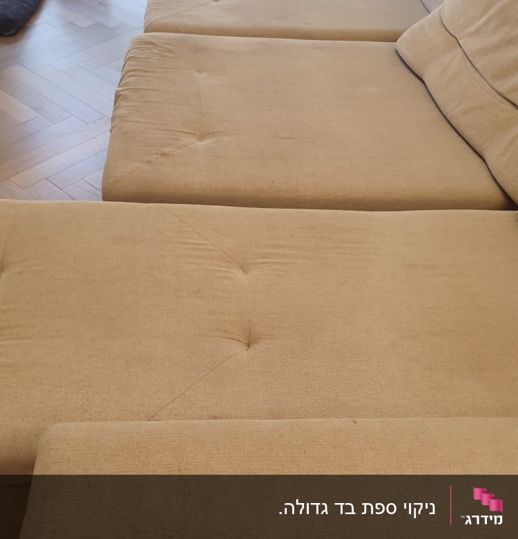 ספה בהירה עם כתמים קלים על המושב